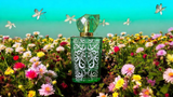 Green decorative perfume bottle surrounded by colorful flowers representing Gucci floral scent for women